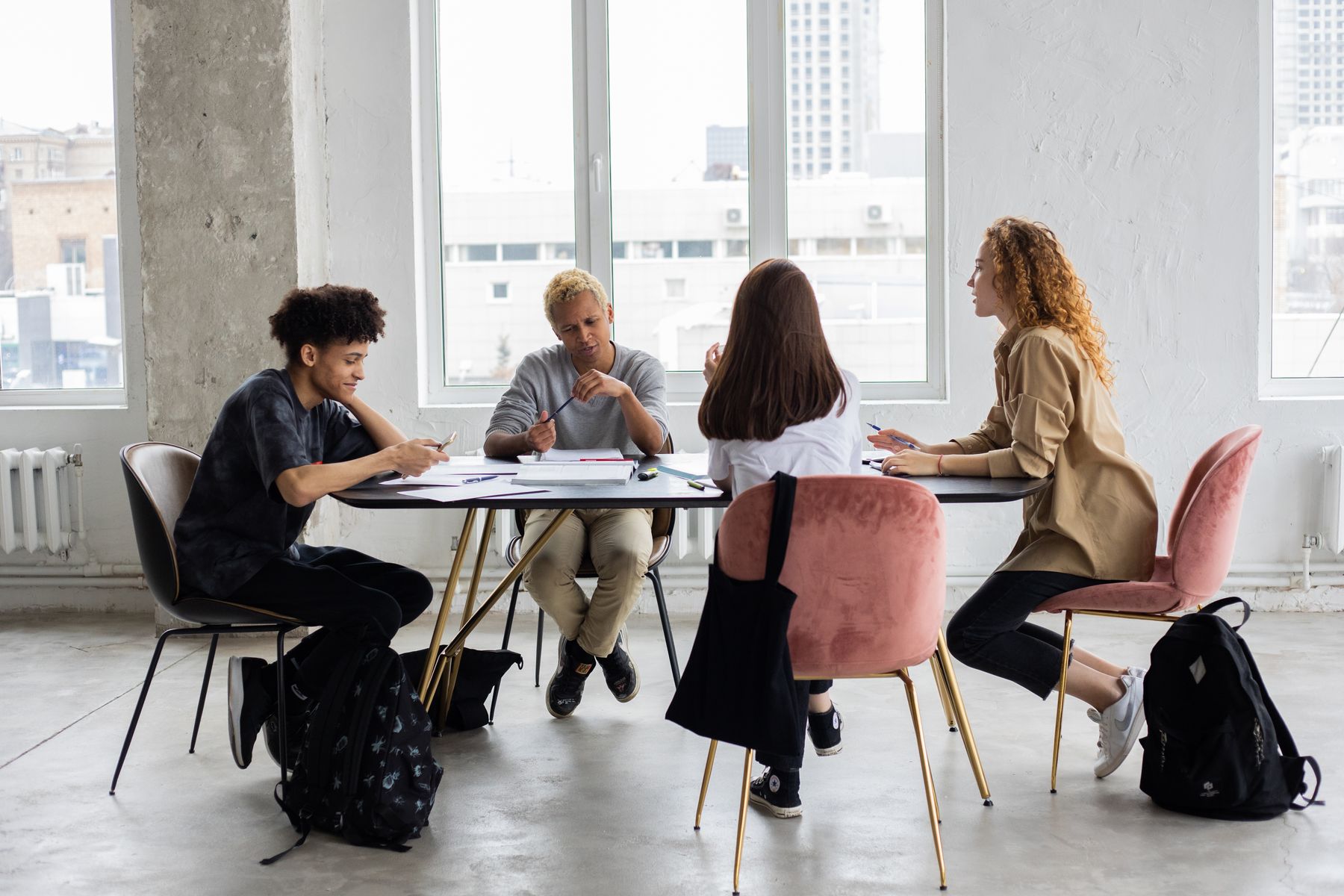 Young people gathered around a table discussing plans and taking notes